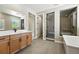 Modern bathroom features a glass shower, double vanity, and plenty of natural light at 1694 Fox Trotter Pt, Castle Rock, CO 80104