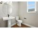 Powder room features a pedestal sink, modern mirror and wood floors at 1694 Fox Trotter Pt, Castle Rock, CO 80104