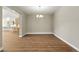 Empty dining room space has wood floors and modern chandelier at 1694 Fox Trotter Pt, Castle Rock, CO 80104