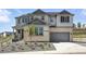 Beautiful two-story home featuring a stone facade, attached two car garage, and manicured front yard at 1694 Fox Trotter Pt, Castle Rock, CO 80104