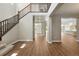 Bright foyer with hardwood floors, a staircase, and views into the kitchen and hallways at 1694 Fox Trotter Pt, Castle Rock, CO 80104