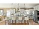 Bright kitchen with stainless steel appliances, large island with bar stool seating, and tile backsplash at 1694 Fox Trotter Pt, Castle Rock, CO 80104