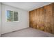 Cozy bedroom featuring a wood accent wall and a window for natural light at 3090 S Telluride St, Aurora, CO 80013