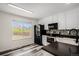 Bright kitchen features sleek, modern black appliances, granite countertops, mosaic backsplash, and refinished cabinets at 3090 S Telluride St, Aurora, CO 80013