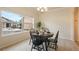 Bright dining space with a round table, four chairs, and a large window offering natural light and neighborhood views at 1520 Symphony Hts, Monument, CO 80132