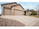Three-car garage and extended driveway of a home with stone and stucco exterior at 1520 Symphony Hts, Monument, CO 80132