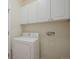 A well-organized laundry room features a white washer and dryer, and upper cabinets for storage at 1520 Symphony Hts, Monument, CO 80132