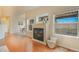 Sunlit living room with a fireplace, hardwood floors, and modern decor at 1520 Symphony Hts, Monument, CO 80132