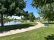 A peaceful walkway through a community park with benches, green grass, and a serene pond at 9540 King Way, Westminster, CO 80031