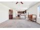 Spacious living room with open floorplan to kitchen, featuring ceiling fan, and a mix of carpet and hardwood flooring at 2015 Wildwood St, Lochbuie, CO 80603