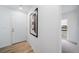 Bright entryway with wood-look flooring, white door, and modern art at 46541 Avery Ln, Bennett, CO 80102