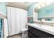 Well-lit bathroom featuring a sleek vanity, modern fixtures, and a shower with a white curtain at 7142 S Hudson Ln, Centennial, CO 80122