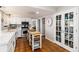 Bright kitchen featuring terracotta tile flooring, white cabinetry, and a central island with butcher block top at 7142 S Hudson Ln, Centennial, CO 80122