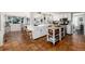 Bright kitchen featuring terracotta tile flooring, white cabinetry, and a central island with butcher block top at 7142 S Hudson Ln, Centennial, CO 80122