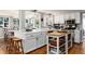 Bright kitchen featuring terracotta tile flooring, white cabinetry, and a central island with butcher block top at 7142 S Hudson Ln, Centennial, CO 80122