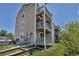 Apartment building exterior with multiple decks, an outdoor grill, and green lawn at 1135 S Gilbert St # 103, Castle Rock, CO 80104