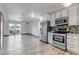 Bright kitchen with stainless appliances, white cabinets, and wood-look floors flowing into a spacious living area at 1135 S Gilbert St # 103, Castle Rock, CO 80104