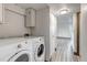 Bright laundry room featuring a stacked washer and dryer unit and upper cabinet storage at 1135 S Gilbert St # 103, Castle Rock, CO 80104