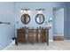 Bathroom featuring a large, ornate double vanity with dark wood and round mirrors at 39681 Swift Creek Cir, Elizabeth, CO 80107