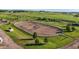 Aerial view of a well-maintained outdoor riding arena with jumps and a pristine green landscape at 39681 Swift Creek Cir, Elizabeth, CO 80107
