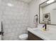 Modern half bathroom featuring white tile walls, stylish vanity, and sleek black fixtures at 2201 Juniper Ct, Boulder, CO 80304