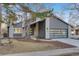 Modern home exterior boasts gray siding, glass garage door, and well-maintained landscaping with mature trees at 2201 Juniper Ct, Boulder, CO 80304