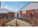 Fenced yard features a brick exterior, landscaping, and clear sky at 7180 Zuni St, Denver, CO 80221