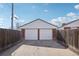 A detached two-car garage with brick siding and white doors is set against a blue sky with a concrete driveway at 7180 Zuni St, Denver, CO 80221