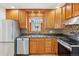 Well-lit kitchen with stainless steel appliances, wood cabinets, and granite countertops at 7180 Zuni St, Denver, CO 80221