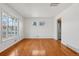 Sunlit open room featuring sleek hardwood floors and stainless steel appliances nearby at 7180 Zuni St, Denver, CO 80221
