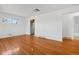 Bright living room with pristine hardwood floors, white walls, and stainless steel appliances nearby at 7180 Zuni St, Denver, CO 80221