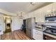 Well-lit kitchen featuring white cabinets, modern appliances, and wood-look flooring at 5757 S Algonquian Way # E, Aurora, CO 80016