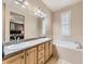 Bathroom features a large soaking tub, double sinks, wood cabinetry and lots of light at 10578 Parkington Ln # 35D, Highlands Ranch, CO 80126