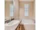 Bathroom with a soaking tub, single sink vanity, large mirror, and tile flooring at 10578 Parkington Ln # 35D, Highlands Ranch, CO 80126
