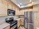 Modern kitchen with stainless steel appliances and ample light wood cabinet space at 10578 Parkington Ln # 35D, Highlands Ranch, CO 80126