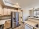 Bright kitchen features stainless steel refrigerator and stone countertops at 10578 Parkington Ln # 35D, Highlands Ranch, CO 80126