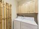 Laundry room features washer, dryer, cabinets, and unique hanging storage at 10578 Parkington Ln # 35D, Highlands Ranch, CO 80126