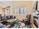 Cozy living room with a fireplace, plush seating, and bright windows with shutters at 10578 Parkington Ln # 35D, Highlands Ranch, CO 80126
