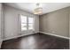 Well-lit bedroom with hardwood floors, neutral walls, and two windows at 7609 S Country Club Pkwy, Aurora, CO 80016