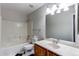 Bathroom featuring a large vanity mirror and a tub with tiled enclosure at 8416 Pebble Creek Way # 203, Highlands Ranch, CO 80126