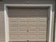 Neutral-toned garage door providing secure parking and storage, featuring a classic panel design at 8416 Pebble Creek Way # 203, Highlands Ranch, CO 80126