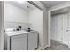 Functional laundry room featuring a modern washer and dryer set with shelving at 8416 Pebble Creek Way # 203, Highlands Ranch, CO 80126
