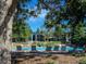 Community pool surrounded by lounge chairs and lush greenery, perfect for relaxation and recreation at 8416 Pebble Creek Way # 203, Highlands Ranch, CO 80126
