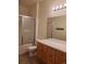 A full bathroom with glass shower doors, wood cabinet, and large mirror at 14251 E 1St Dr # 305, Aurora, CO 80011