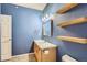 Bathroom featuring a light wood vanity, toilet, and a large mirror at 14251 E 1St Dr # 305, Aurora, CO 80011