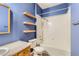 Bathroom featuring a shower-tub combo, toilet, vanity, and wood shelves at 14251 E 1St Dr # 305, Aurora, CO 80011