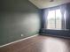 View of a room with a large window covered by translucent curtains and dark laminate floors at 14251 E 1St Dr # 305, Aurora, CO 80011