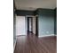 A view of a room with dark laminate floors, a walk-in closet, and doors into other rooms at 14251 E 1St Dr # 305, Aurora, CO 80011