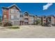 Exterior view of a well-maintained three-story condo building with ample parking at 14251 E 1St Dr # 305, Aurora, CO 80011