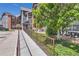 View of a ramp leading to a condo building with manicured landscaping and a green lawn at 14251 E 1St Dr # 305, Aurora, CO 80011